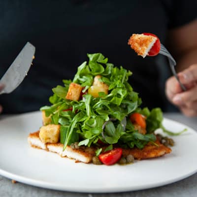 Parmesan crusted chicken breast, arugula, baby gem tomatoes, red onion, lemon caper dressing.